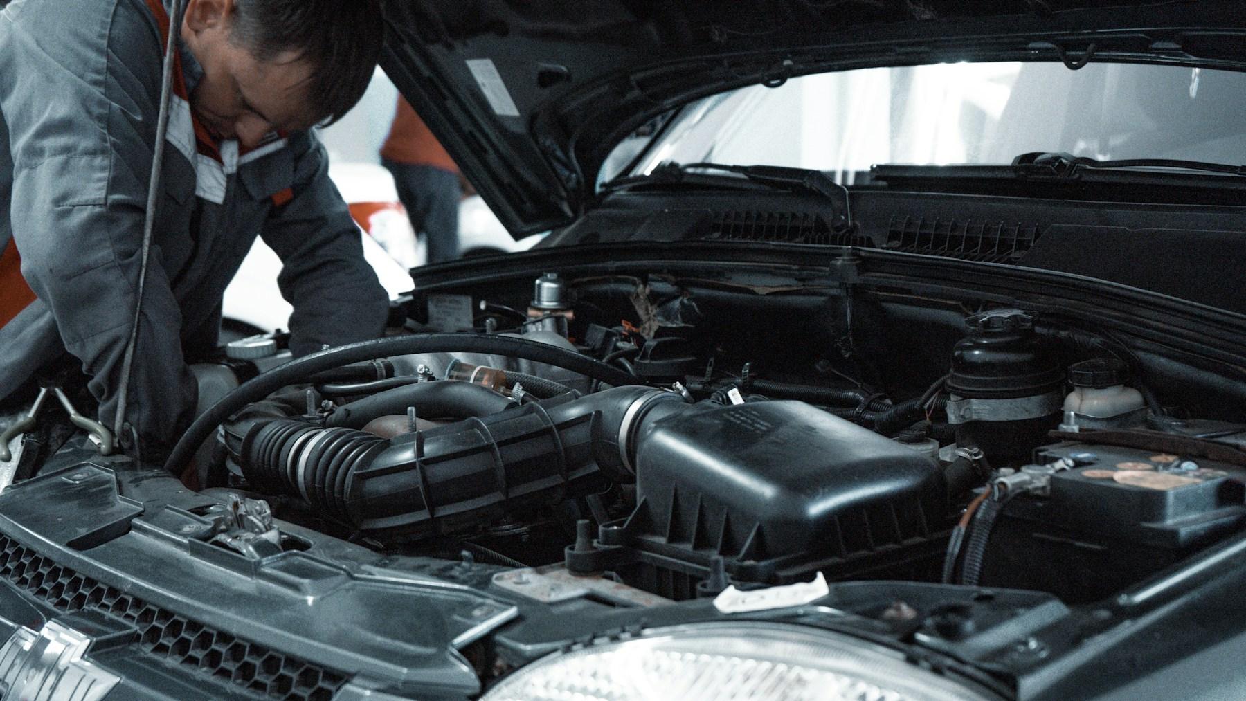 Mechanic inspecting the engine bay of a car
